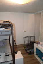 Bedroom with hardwood / wood-style flooring and a textured ceiling