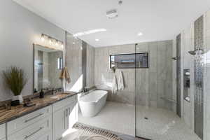 Bathroom with plus walk in shower, vanity, tile patterned flooring, and tile walls