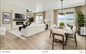 Living room featuring ceiling fan with notable chandelier, a textured ceiling, and light hardwood / wood-style floors