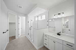 Bathroom with tile patterned floors, vanity, a textured ceiling, and walk in shower