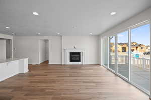 Unfurnished living room featuring wood-type flooring and a textured ceiling