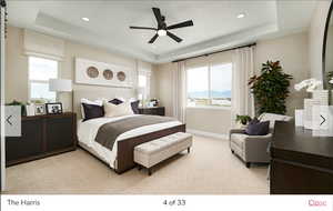 Carpeted bedroom with a mountain view, ceiling fan, and a raised ceiling