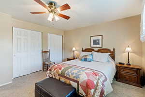 Carpeted bedroom with a closet and ceiling fan