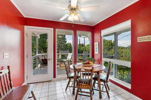 Tiled dining room featuring a wealth of natural light, ceiling fan, and crown molding