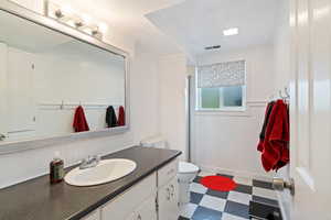 Bathroom with vanity, toilet, and a textured ceiling