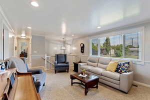 Living room featuring ornamental molding and light colored carpet