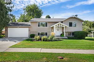 Split foyer home with a front yard and a garage