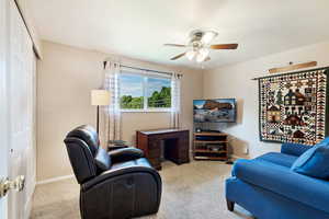 Living room with ceiling fan and light colored carpet