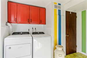 Laundry area with cabinets and washer and clothes dryer