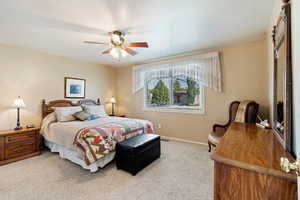 Bedroom with ceiling fan and light colored carpet