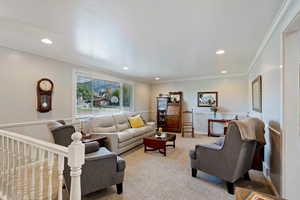 Carpeted living room with ornamental molding