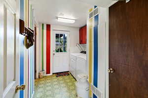 Clothes washing area featuring cabinets and washer and dryer