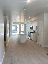 Kitchen with white shaker cabinets, stainless steel appliances, and white quartz counters.