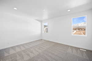 Unfurnished room featuring carpet and plenty of natural light