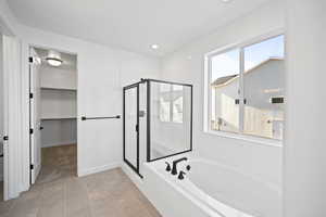 Bathroom featuring shower with separate bathtub and tile patterned floors