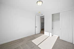 Unfurnished bedroom with carpet flooring and a closet