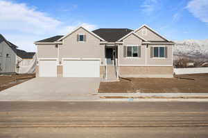 View of front of home with a mountain view and a garage