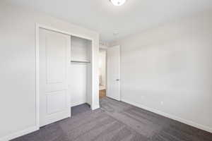 Unfurnished bedroom featuring carpet floors and a closet