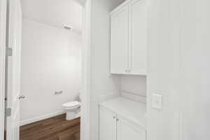 Bathroom featuring wood-type flooring and toilet