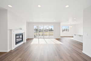 Unfurnished living room featuring a chandelier and hardwood / wood-style flooring