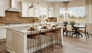 Kitchen featuring wall chimney range hood, and light hardwood / wood-style floors.Picture of model colors and materials may vary.