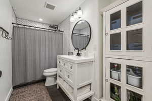 Bathroom featuring toilet, vanity, and tile patterned floors