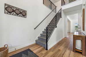 Staircase featuring hardwood / wood-style flooring and a high ceiling