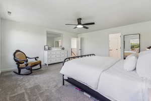 Primary Bedroom with ceiling fan, light carpet, and connected bathroom