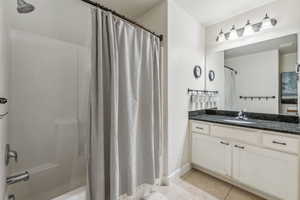 Bathroom featuring tile patterned flooring, vanity, and shower / bath combo with shower curtain