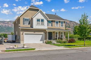 View of front facade with a mountain view, a garage, and a front lawn