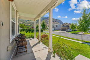 View of patio with a garage, a mountain view, and covered porch