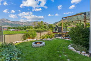 View of yard featuring a deck with mountain view and an outdoor fire pit