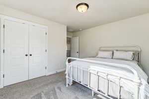 Carpeted bedroom featuring a closet