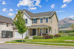 View of front of house featuring a mountain view, a garage, and a front yard