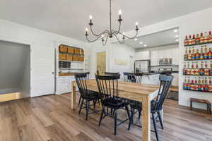 Dining area with light wood-type flooring and a chandelier