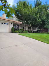 View of front facade featuring a garage and a front yard