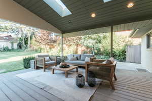 Wooden deck featuring a lawn and an outdoor hangout area