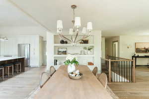 Dining space featuring a notable chandelier and light hardwood / wood-style flooring