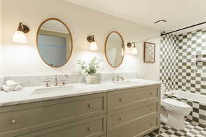 Full bathroom with vanity, toilet, and tiled shower / bath combo