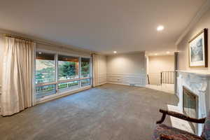 Living room featuring carpet, a fireplace, crown molding and incredible views to the west