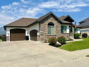 View of front of property featuring a garage and a front lawn