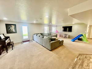 Carpeted living room with a textured ceiling