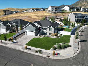 View of front of property with a garage, a front lawn, and a mountain view