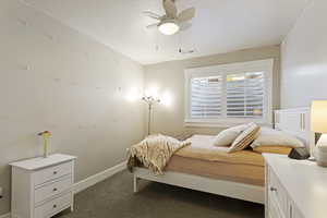 Bedroom with ceiling fan and dark carpet