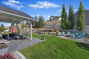 View of yard with an outdoor fire pit and a patio