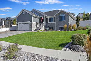 View of front of property featuring a front lawn and a garage