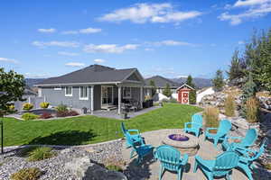 Rear view of house featuring an outdoor fire pit, a patio area, a shed, and a yard