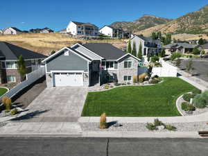 View of front of property with a mountain view, a front yard, and a garage