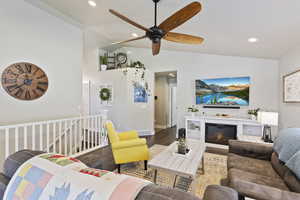 Living room with ceiling fan, vaulted ceiling, and hardwood / wood-style floors