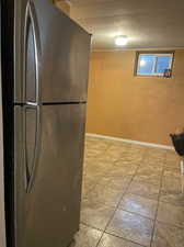 Kitchen with stainless steel refrigerator and light tile patterned floors